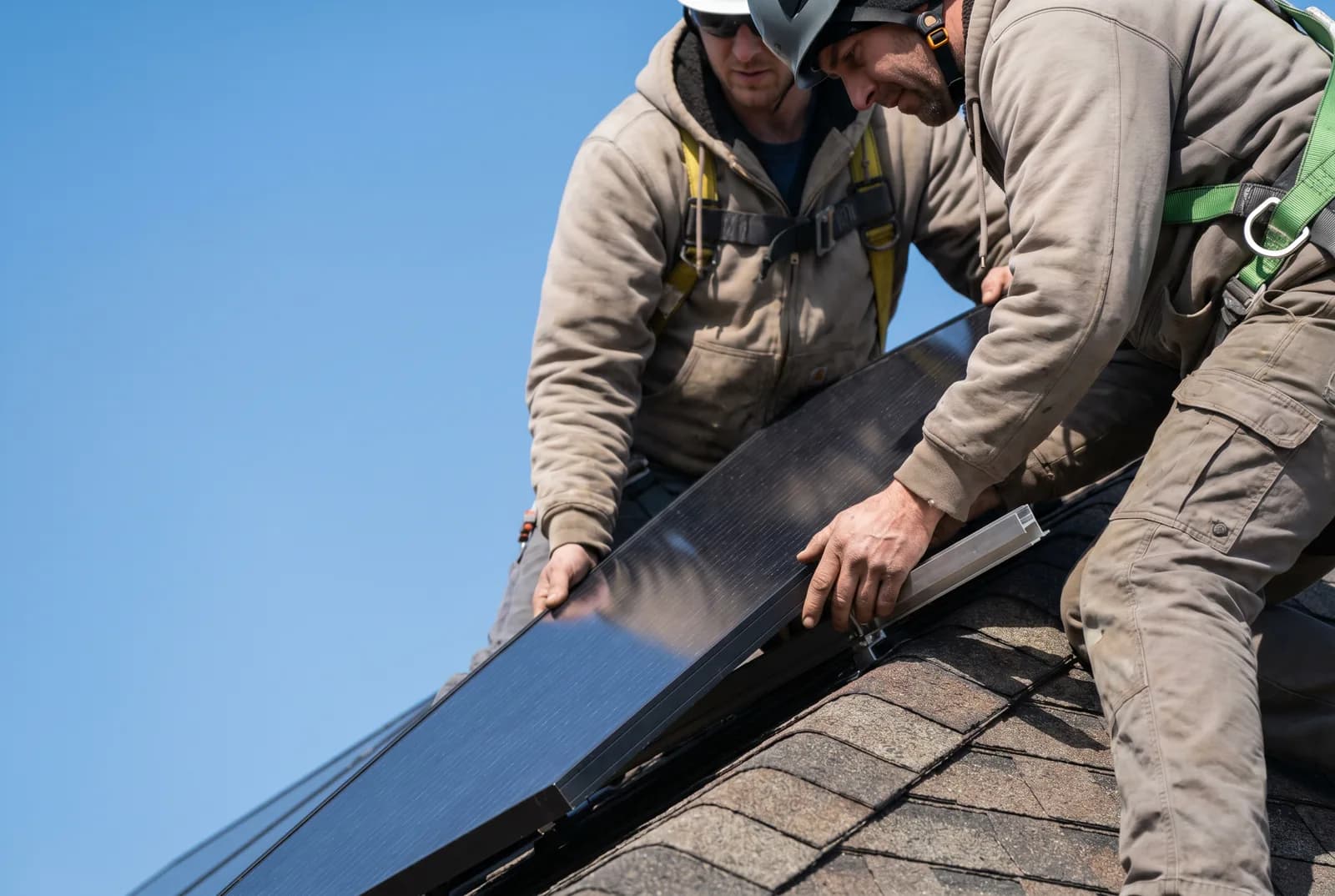 Installers placing solar panels on a roof in Laval