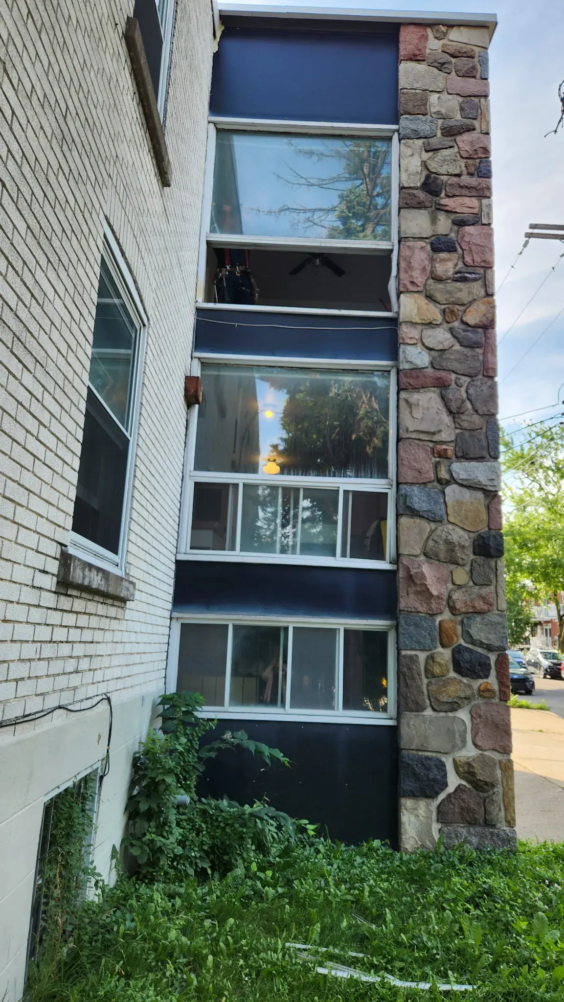 Multi-unit facade in Saint-Léonard after the work, dark cladding and new windows