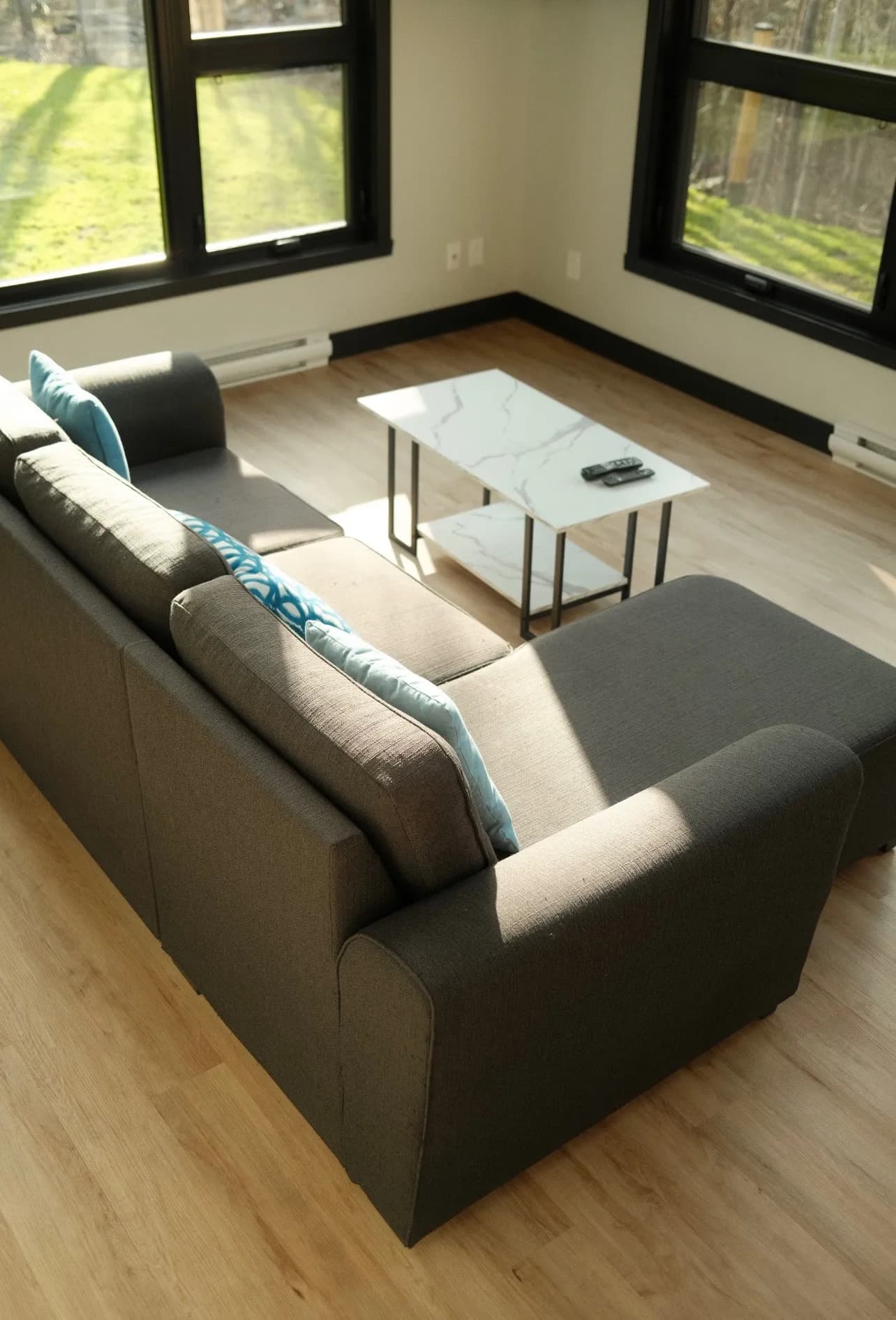 Salon lumineux avec fenêtres d’angle à cadre noir, un projet Renoconnect